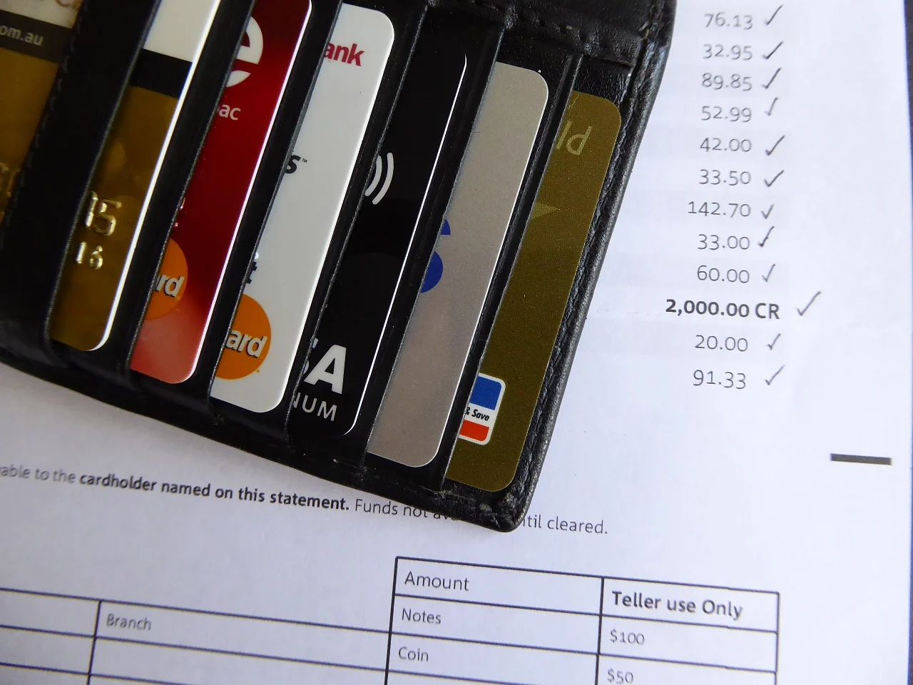 several credit cards and a bill behind them